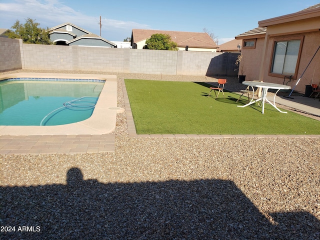 view of swimming pool featuring a yard and a patio area