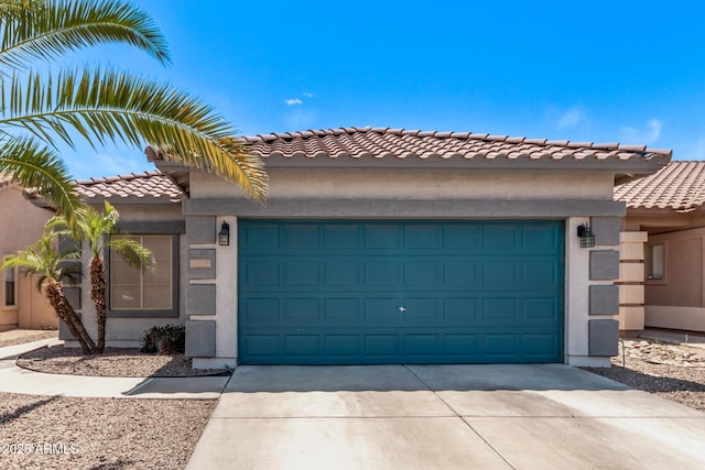 mediterranean / spanish house featuring concrete driveway, stucco siding, a tile roof, and a garage