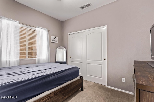 bedroom with visible vents, carpet, baseboards, and a closet