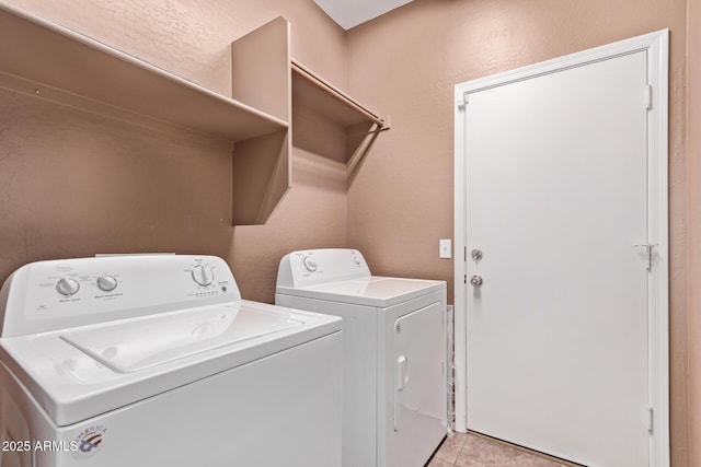 laundry area featuring laundry area, light tile patterned flooring, and washing machine and clothes dryer