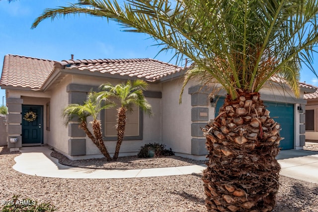 mediterranean / spanish-style home featuring a garage, a tiled roof, driveway, and stucco siding