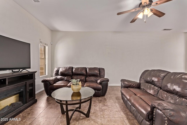 living room featuring baseboards, tile patterned flooring, and a ceiling fan