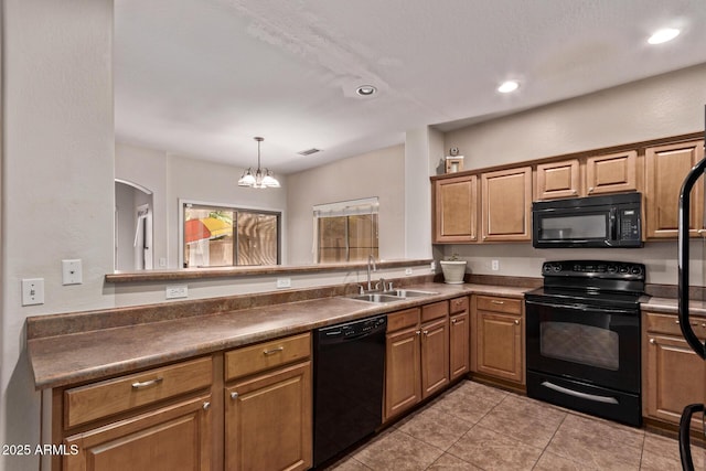 kitchen featuring dark countertops, a notable chandelier, a sink, light tile patterned floors, and black appliances