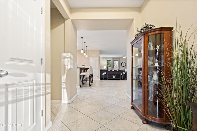 interior space with baseboards and light tile patterned flooring