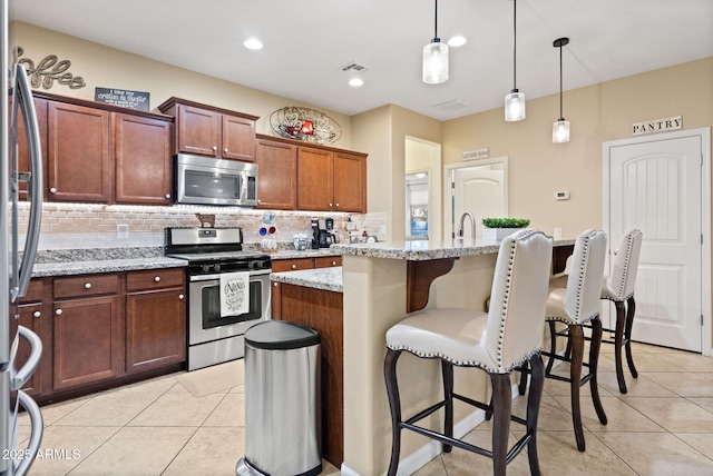 kitchen with stainless steel appliances, tasteful backsplash, visible vents, and light tile patterned floors