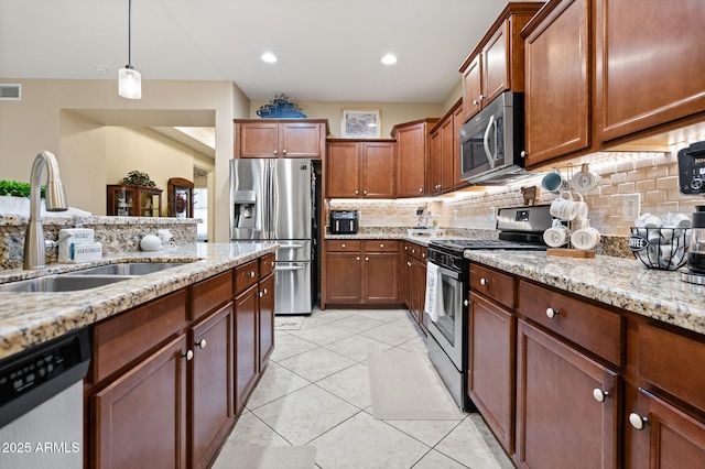 kitchen featuring stainless steel appliances, backsplash, a sink, and light stone countertops