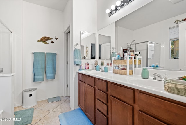 bathroom featuring double vanity, a stall shower, tile patterned flooring, and a sink