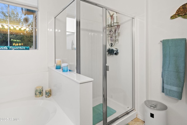 bathroom featuring a garden tub, a shower stall, and tile patterned flooring