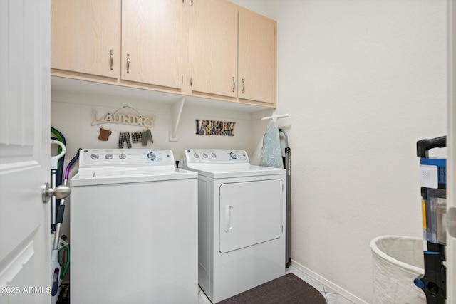 laundry room featuring separate washer and dryer, cabinet space, and baseboards