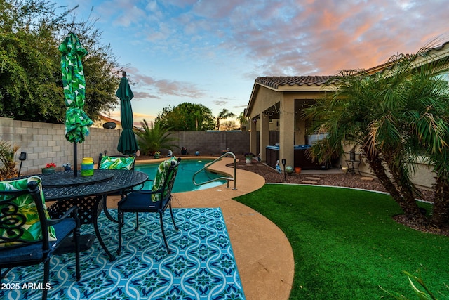 view of swimming pool with a hot tub, a fenced in pool, a patio, a fenced backyard, and a yard