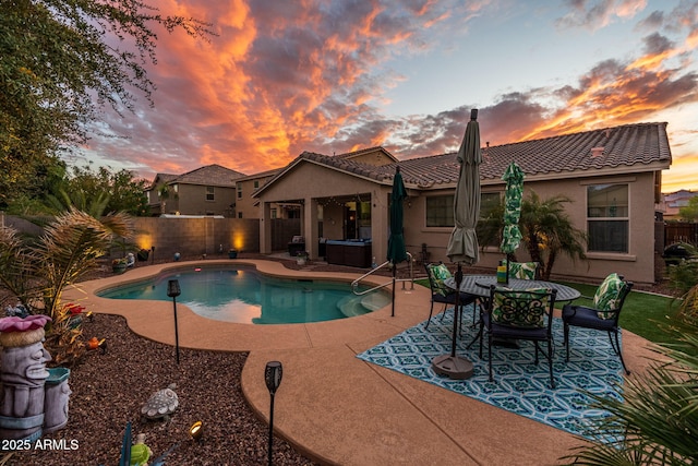 pool at dusk featuring a patio, a fenced backyard, and a fenced in pool