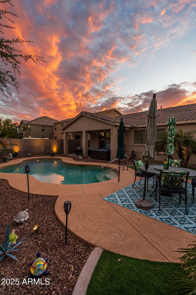 view of swimming pool featuring a patio, a fenced backyard, a fenced in pool, and a hot tub