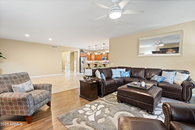 living area featuring visible vents, baseboards, ceiling fan, light wood-type flooring, and recessed lighting