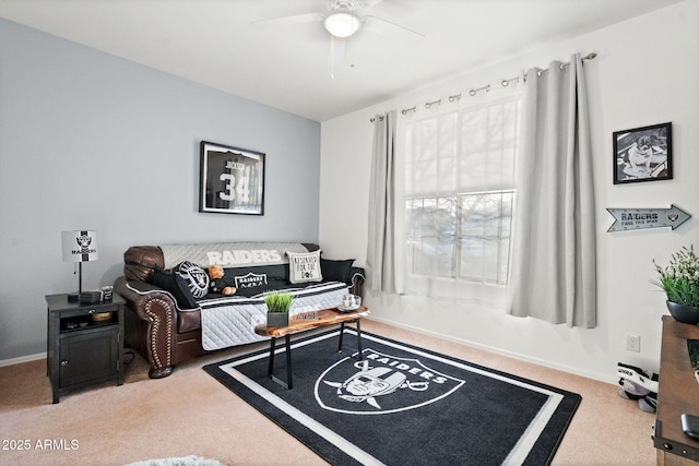 carpeted living area with ceiling fan and baseboards