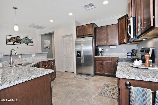 kitchen featuring dark brown cabinets, sink, light stone countertops, pendant lighting, and appliances with stainless steel finishes