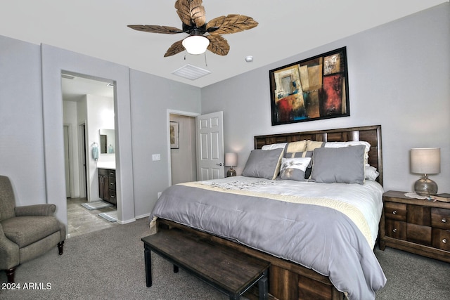 bedroom with ensuite bath, light colored carpet, and ceiling fan