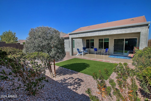 rear view of property with a patio and a lawn