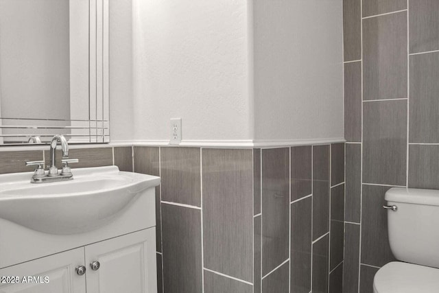 11983 W Fillmore St, Avondale, AZ 85323 - bathroom with toilet, a wainscoted wall, tile walls, and vanity