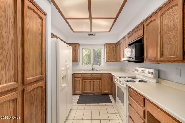 5200 S Lakeshore Dr Unit 206, Tempe, AZ 85283 - kitchen with white appliances, a sink, light tile patterned floors, brown cabinetry, and light countertops