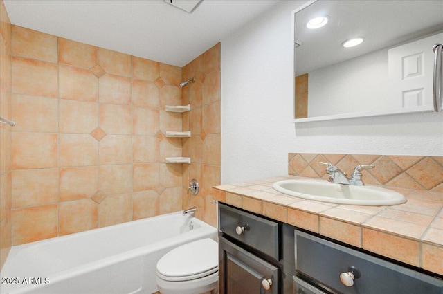 full bathroom with toilet, vanity, and tiled shower / bath