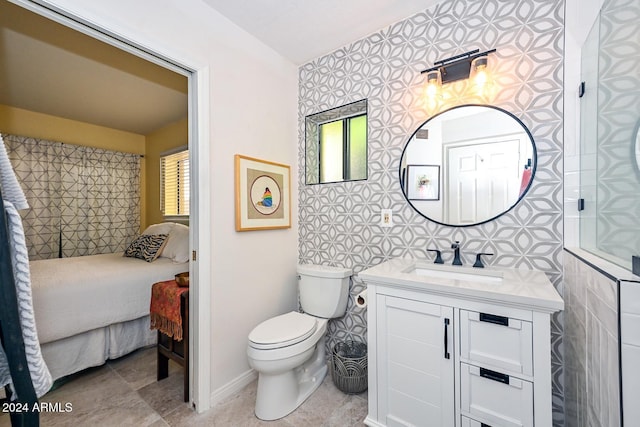 bathroom with tile walls, vanity, toilet, and tile patterned flooring