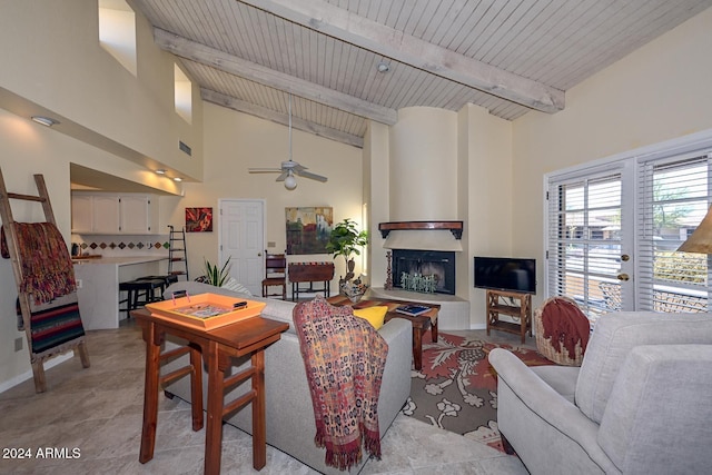 living room featuring beamed ceiling, ceiling fan, a large fireplace, and wooden ceiling