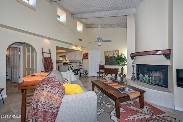 living room featuring plenty of natural light, wood ceiling, a tile fireplace, and ceiling fan