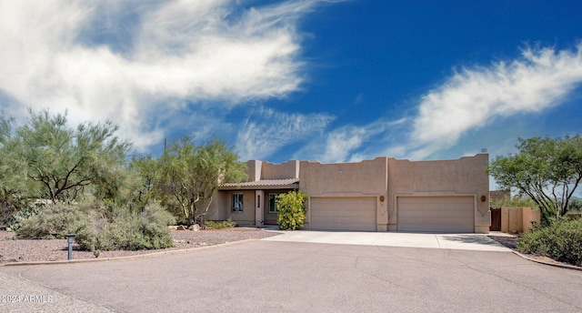 pueblo-style home with a garage