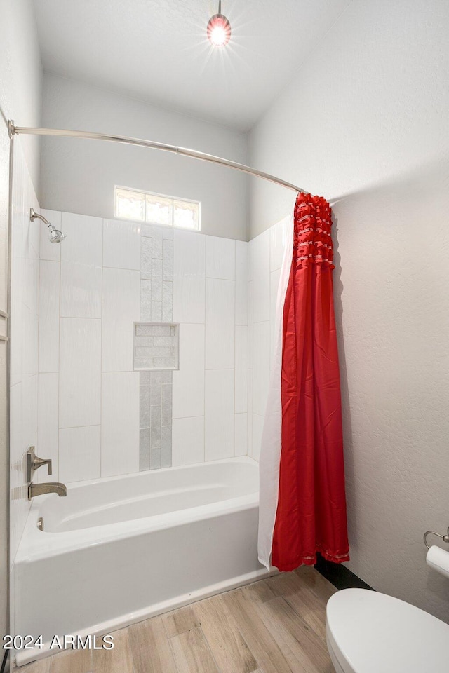 bathroom with shower / tub combo, toilet, and hardwood / wood-style floors