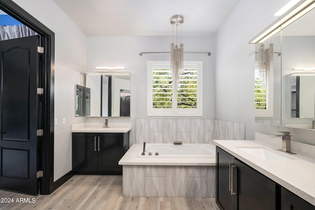 bathroom with wood-type flooring, vanity, and a bathing tub