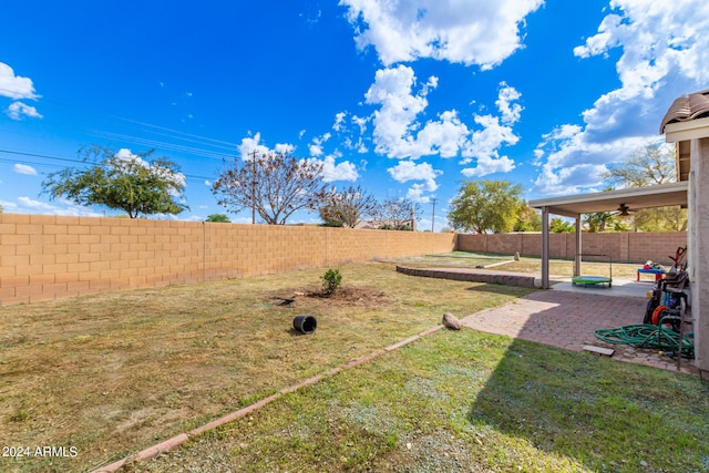 view of yard featuring ceiling fan and a patio