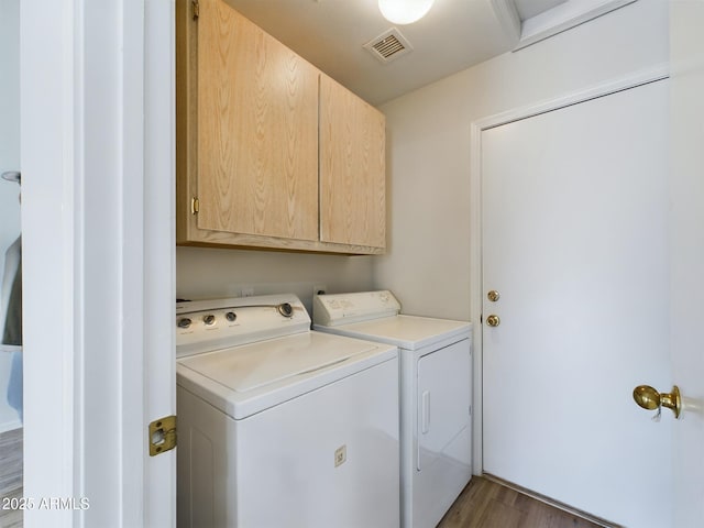 washroom featuring cabinets, dark hardwood / wood-style floors, and washer and dryer