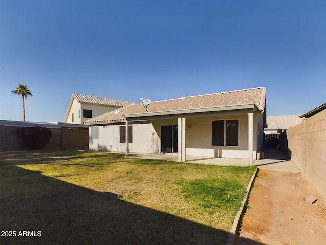 rear view of property with a yard and a patio