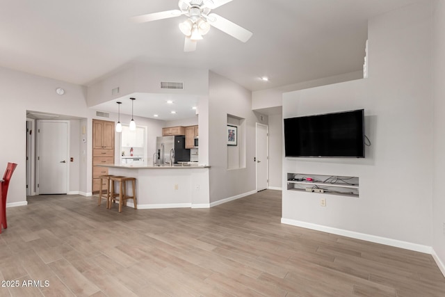 unfurnished living room with ceiling fan and light hardwood / wood-style flooring