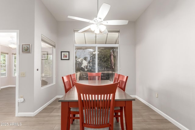 dining space featuring ceiling fan, wood-type flooring, and a healthy amount of sunlight