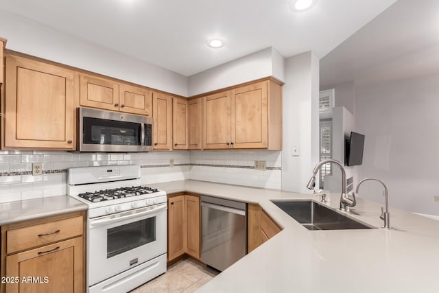 kitchen featuring sink, appliances with stainless steel finishes, tasteful backsplash, light tile patterned flooring, and kitchen peninsula