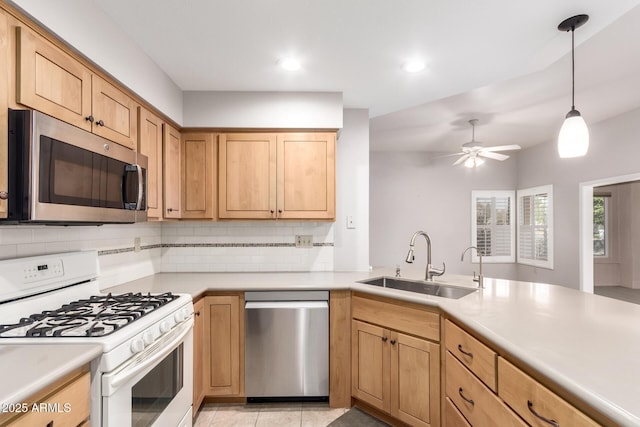 kitchen featuring sink, tasteful backsplash, pendant lighting, ceiling fan, and stainless steel appliances