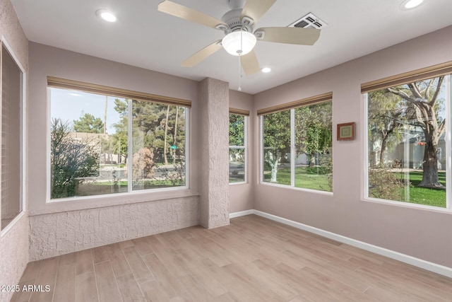 unfurnished sunroom with ceiling fan and a healthy amount of sunlight