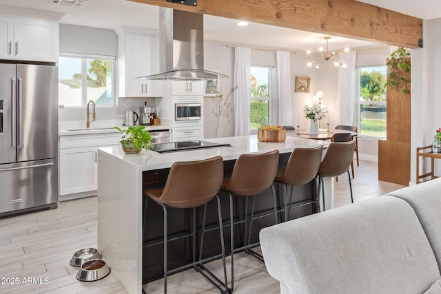 1702 W Glenrosa Ave, Phoenix, AZ 85015 - kitchen featuring stainless steel appliances, island range hood, a sink, a kitchen bar, and light countertops