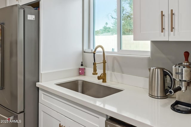 1702 W Glenrosa Ave, Phoenix, AZ 85015 - kitchen featuring freestanding refrigerator, a sink, white cabinetry, and light countertops