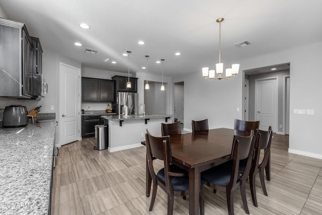 dining area with a notable chandelier and sink