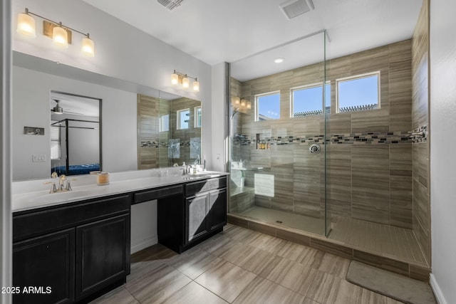 bathroom featuring vanity, ceiling fan, and a tile shower