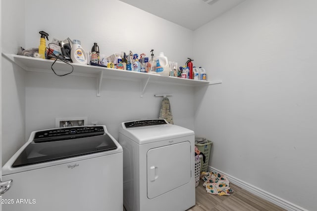 washroom with washer and clothes dryer and light hardwood / wood-style floors