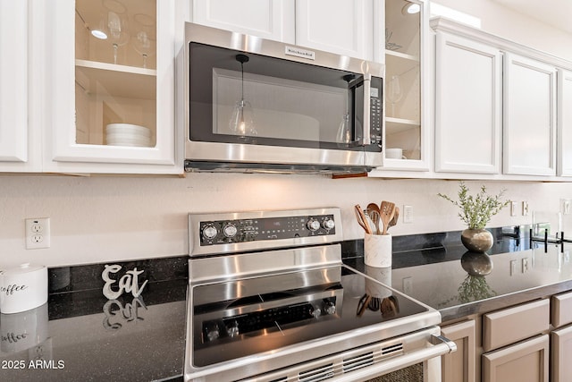 kitchen with dark countertops, white cabinetry, and stainless steel appliances