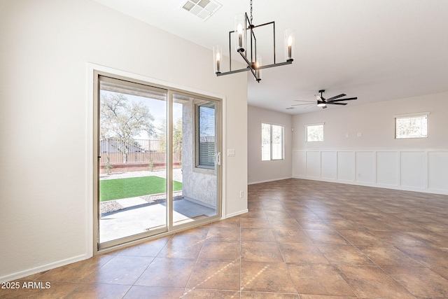 interior space featuring ceiling fan with notable chandelier, visible vents, and baseboards