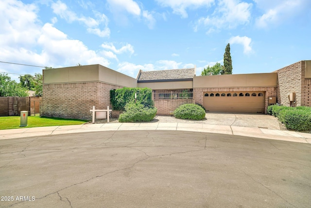 7037 N 11th Dr, Phoenix, AZ 85021 - view of front of property featuring stucco siding, an attached garage, driveway, and brick siding