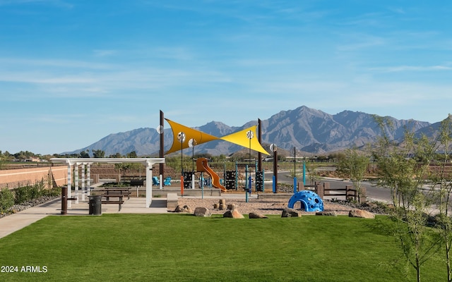 view of community with a yard, playground community, and a mountain view