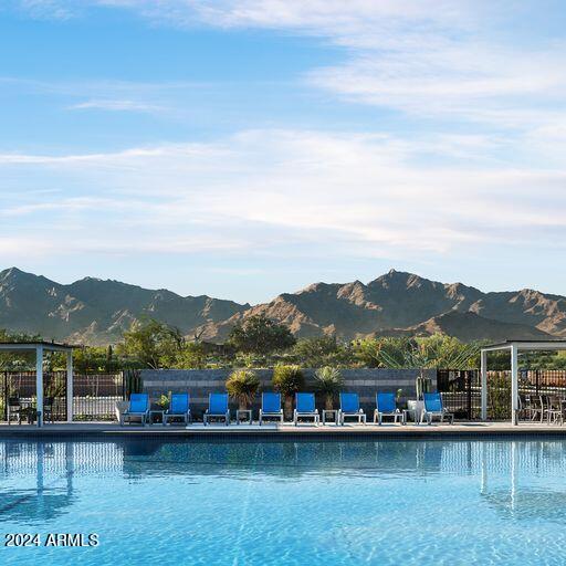 community pool with fence and a mountain view