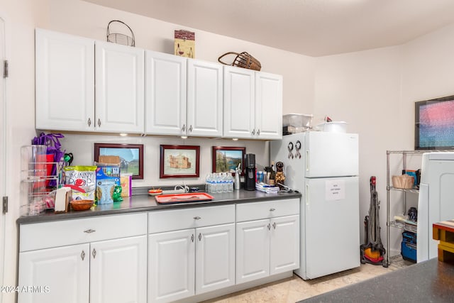 kitchen with white refrigerator and white cabinetry