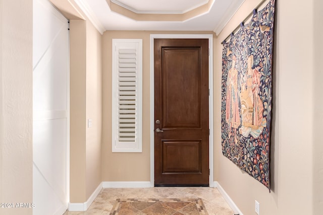 doorway to outside featuring ornamental molding and a tray ceiling